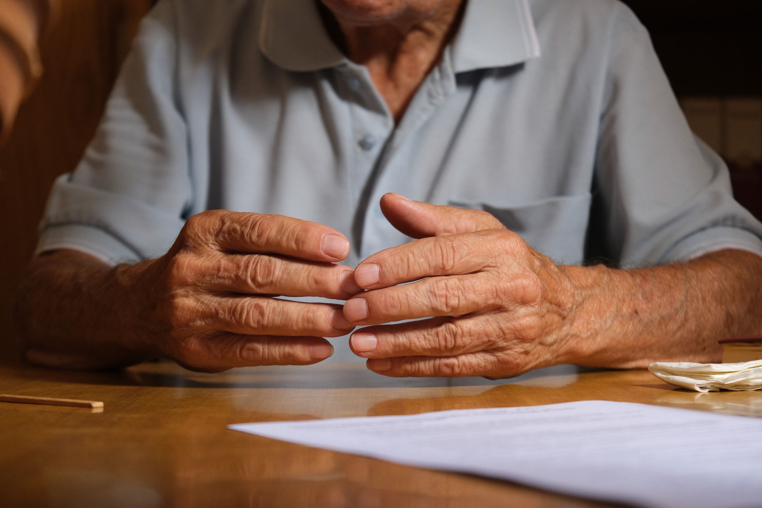 Le mani di Filippo Castro intrecciate sul tavolo, accanto a un foglio